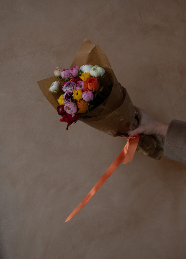 bouquet of bright flowers tied with an orange ribbon 
