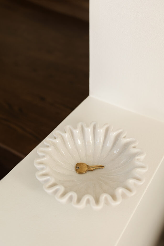 white ceramic bowl with a gold key laying inside 